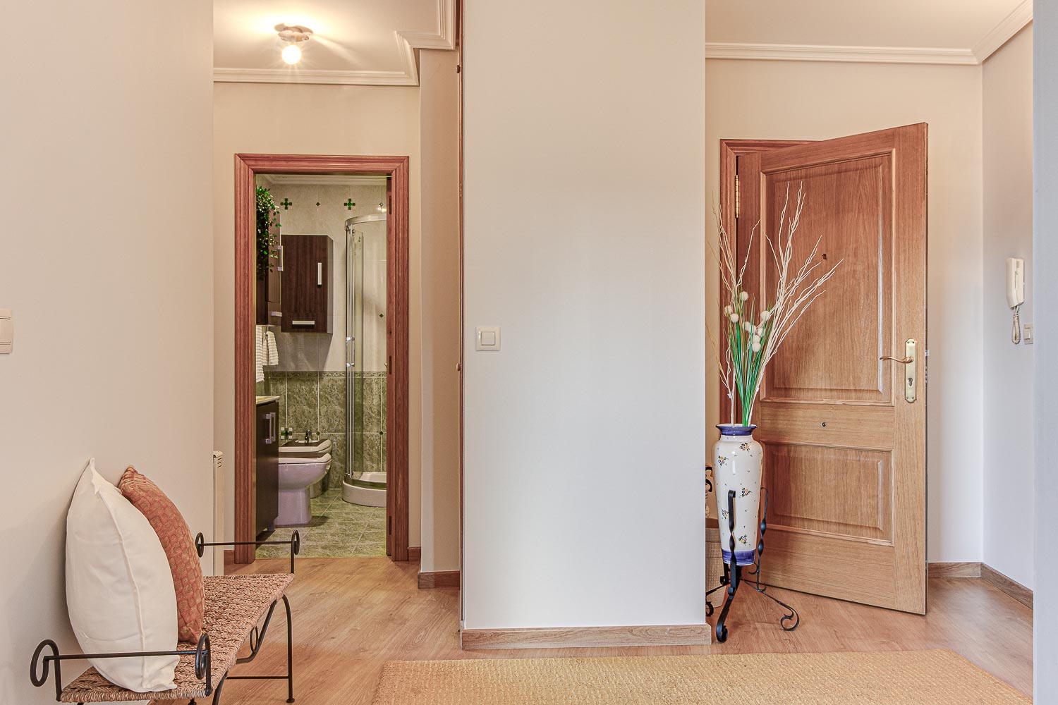 Espacio de recibidor en piso de Vilaboa_ Al fondo se ve el cuarto de baño y la puerta de entrada entreabierta_Home Staging