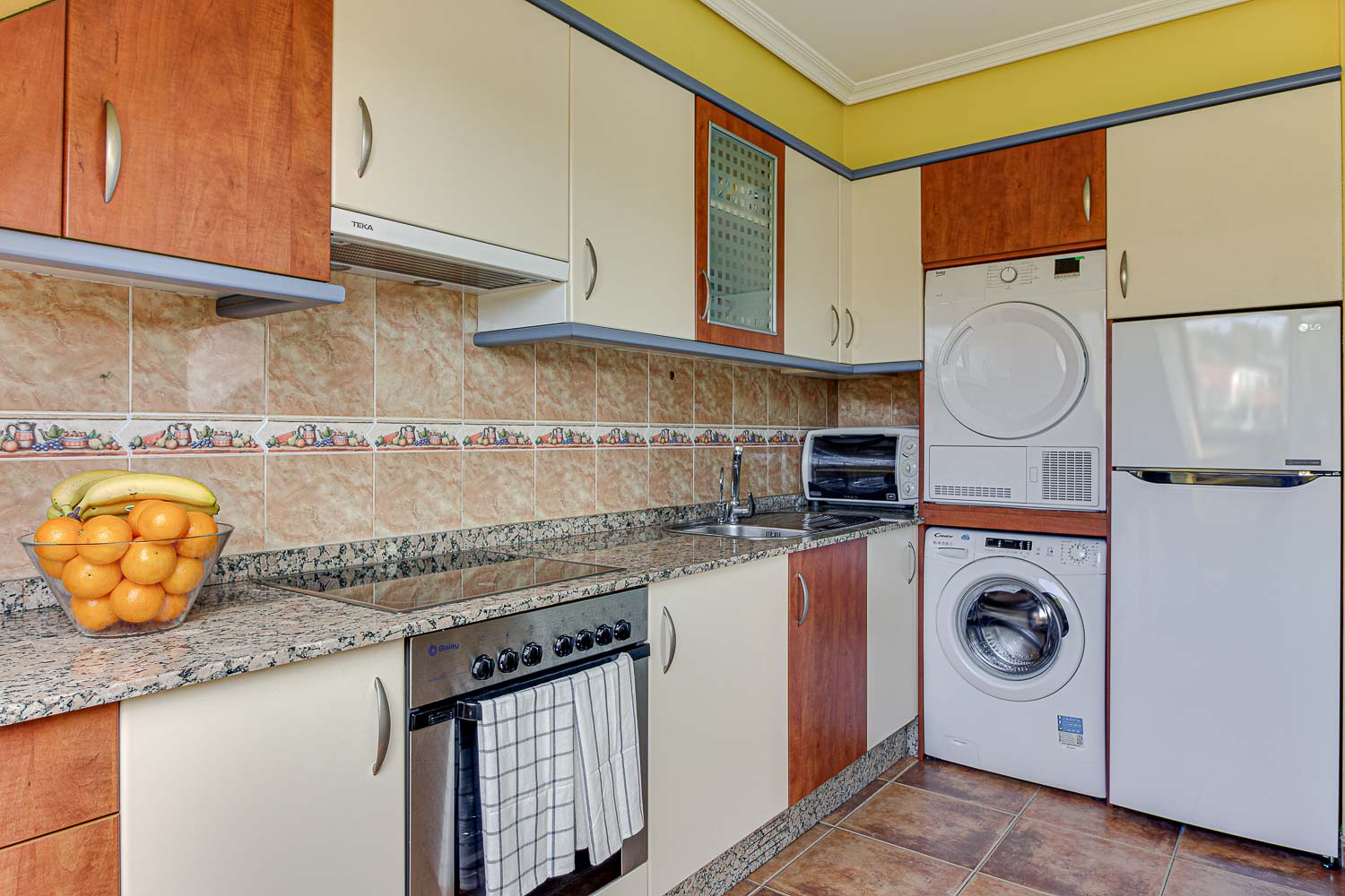 Cocina piso de Vilaboa_ puertas de armarios de distintos colores y azulejo clásico_ lavadora y secadora integradas_ Home Staging