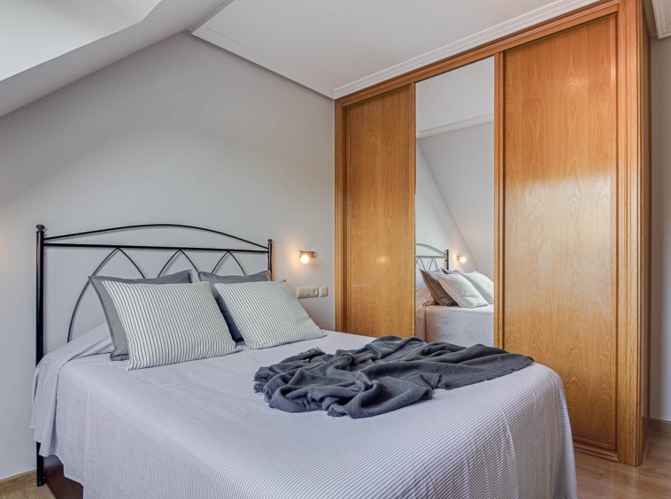 Dormitorio principal en Vilaboa con armarios empotrados_ despejado y limpio + textiles neutros grises_ Home Staging