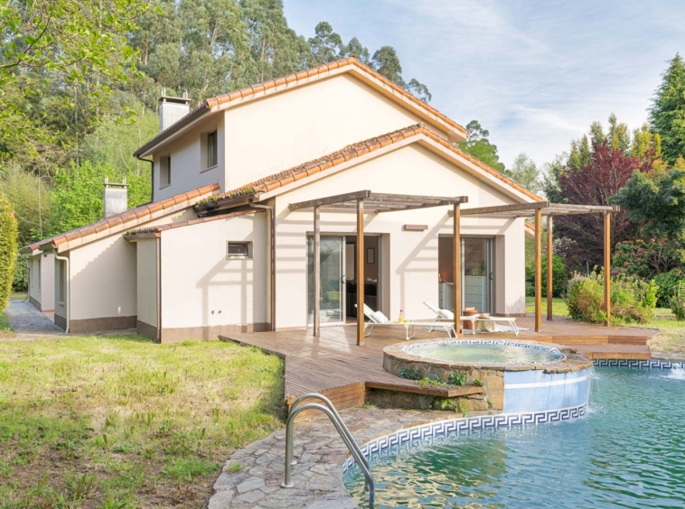 Casa moderna con piscina y jacuzzi en un exuberante jardín verde, con una amplia terraza de madera y zona de relax al aire libre