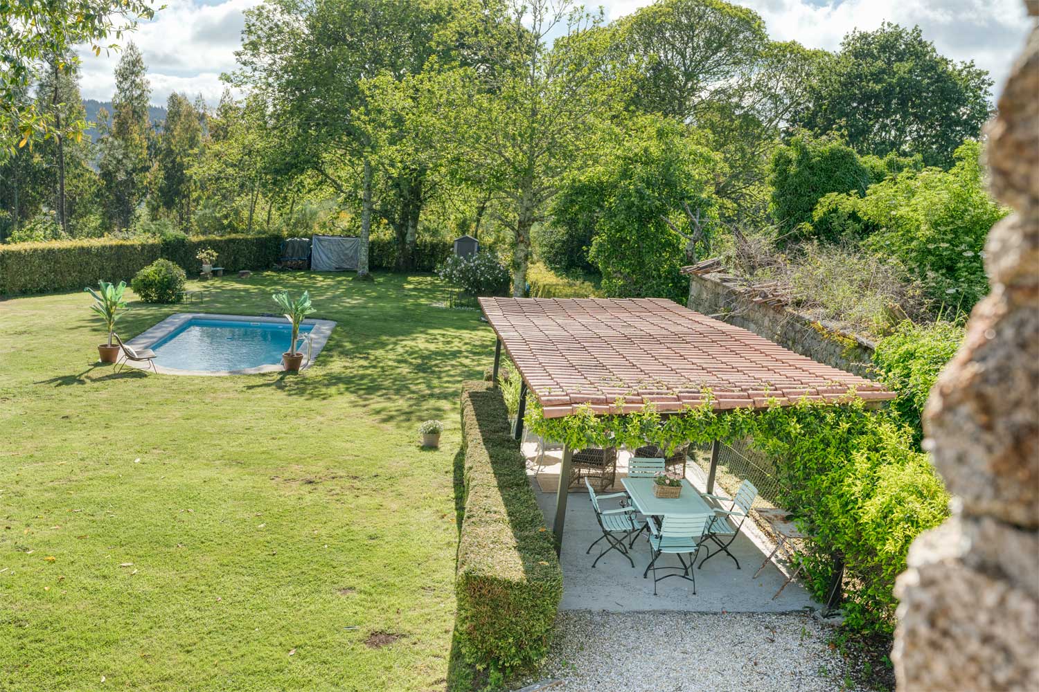 Vista aérea del jardín con piscina y zona de comedor al aire libre de una casa en venta en Aranga por Morando.