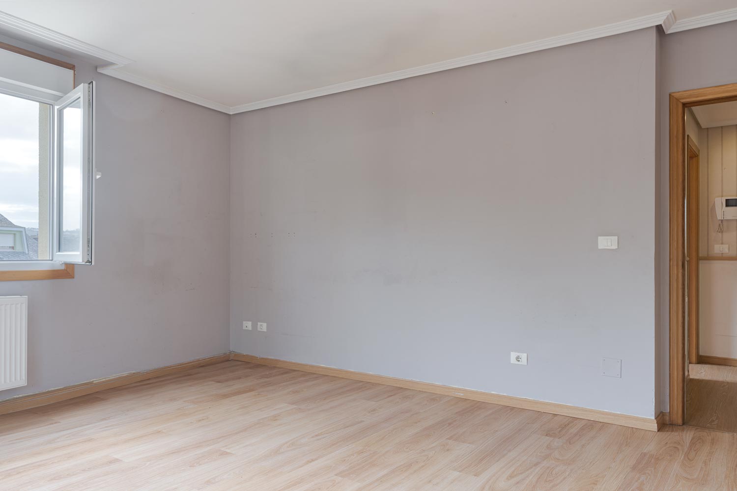 Salón con ventana abierta y suelo laminado en venta por morando inmbiliaria