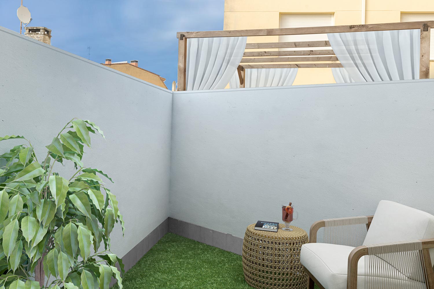 Terraza privada con decoración minimalista, césped artificial y una silla con mesa auxiliar, en venta en Sada por Morando Inmobiliaria.