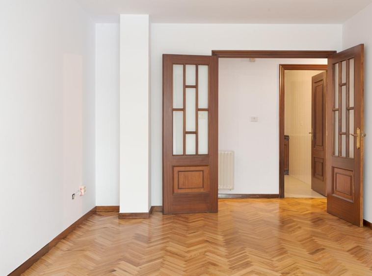 Salón luminoso con suelo de parquet y puerta de madera, disponible en venta en Sada por Morando Inmobiliaria.