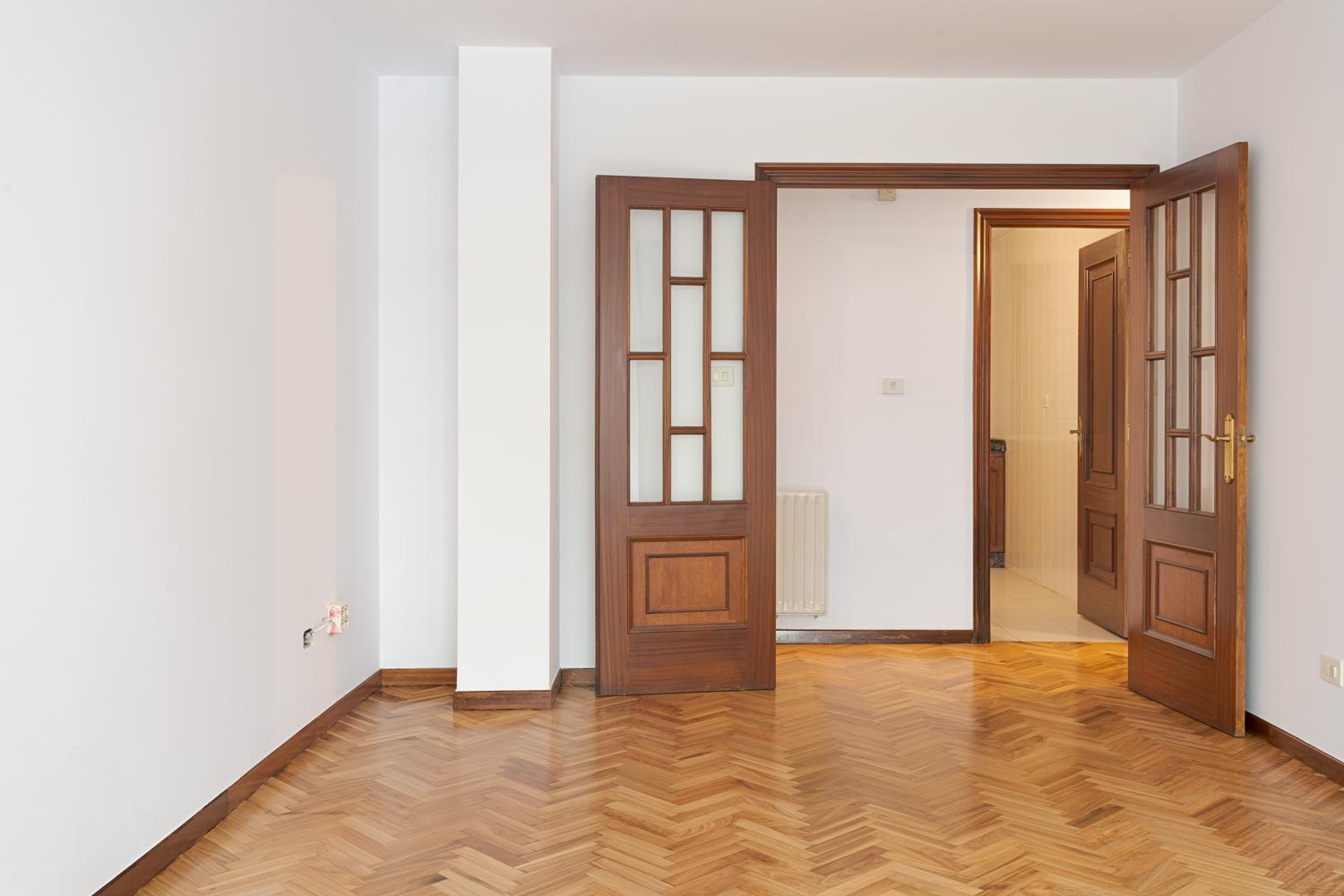 Salón luminoso con suelo de parquet y puerta de madera, disponible en venta en Sada por Morando Inmobiliaria.