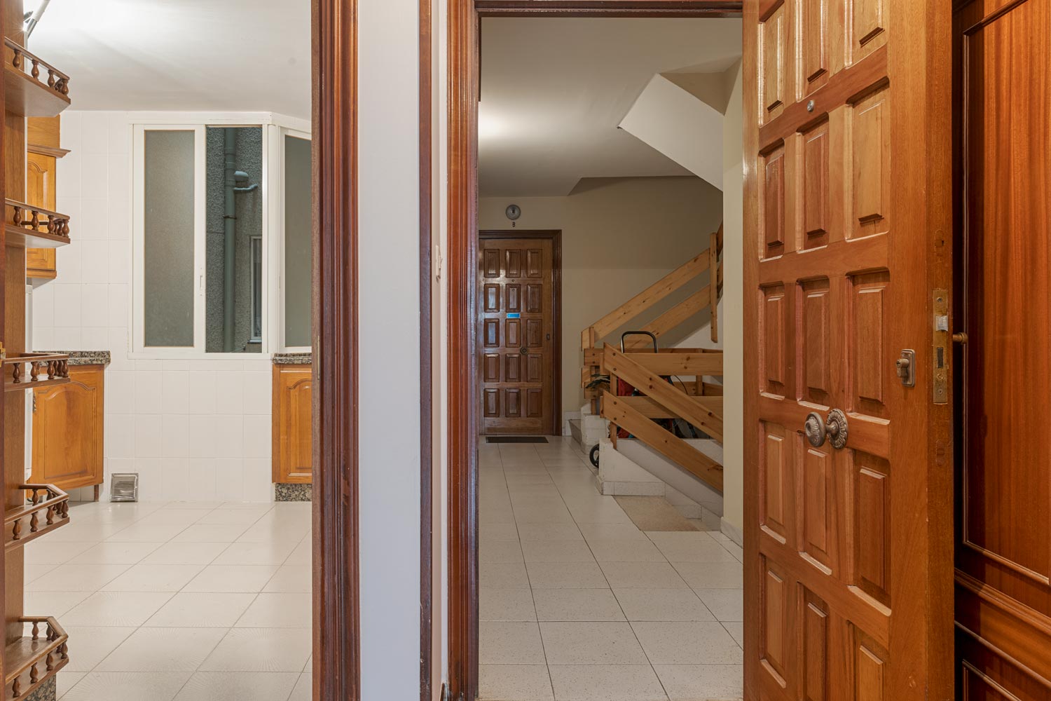 Entrada del piso con puerta de madera y acceso a la cocina, en venta en Sada por Morando Inmobiliaria.