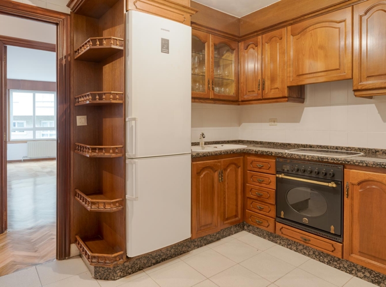 Cocina equipada con muebles de madera y electrodomésticos modernos, en venta en Sada por Morando Inmobiliaria.