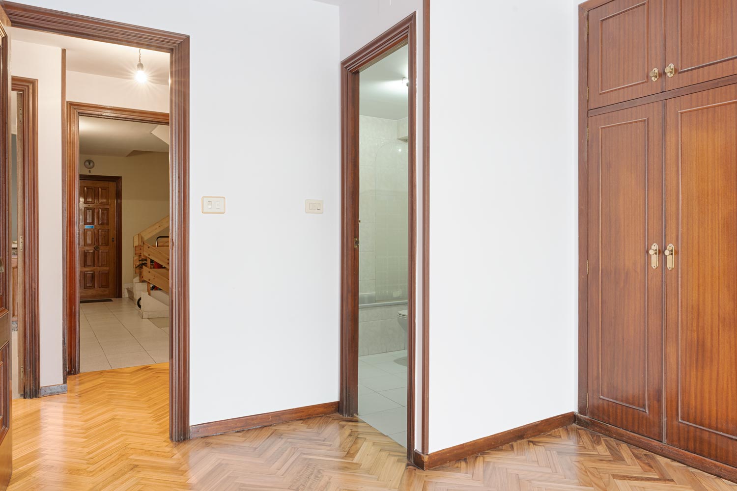 Habitación con acceso a baño privado y armario empotrado de madera en piso en venta en Sada por Morando Inmobiliaria.