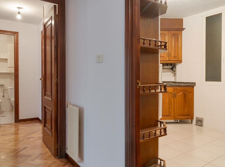 Cocina con muebles de madera y acceso a un baño en piso en venta en Sada por Morando Inmobiliaria.