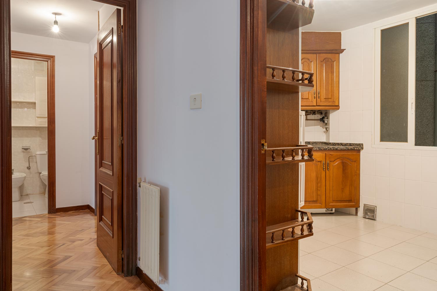 Cocina con muebles de madera y acceso a un baño en piso en venta en Sada por Morando Inmobiliaria.