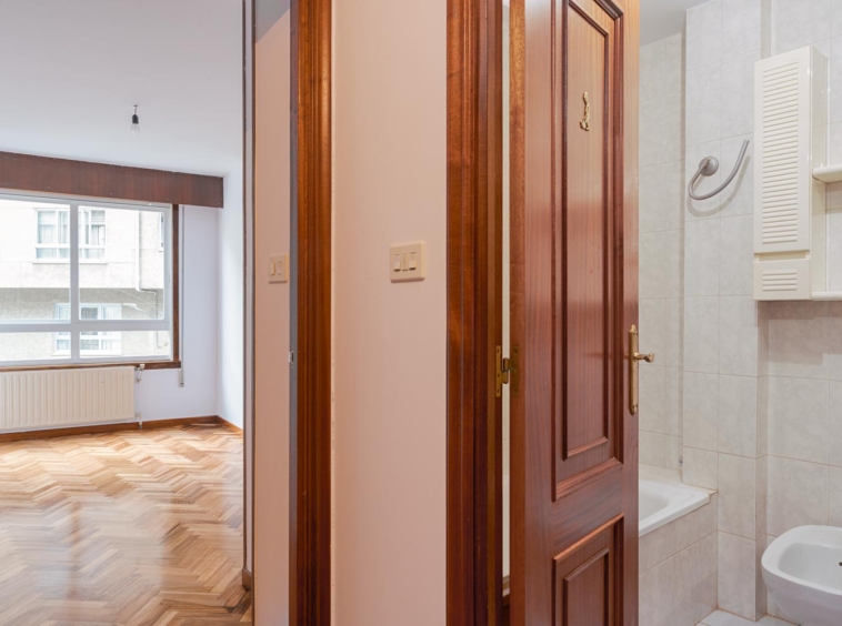 Vista del baño y una habitación con ventana desde un pasillo en piso en venta en Sada por Morando Inmobiliaria.