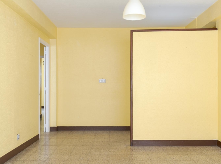 Sala de estar vacía en piso en venta en Sada, con paredes en tono amarillo suave y una disposición amplia, ideal para personalizar. Gestionado por Morando Inmobiliaria.