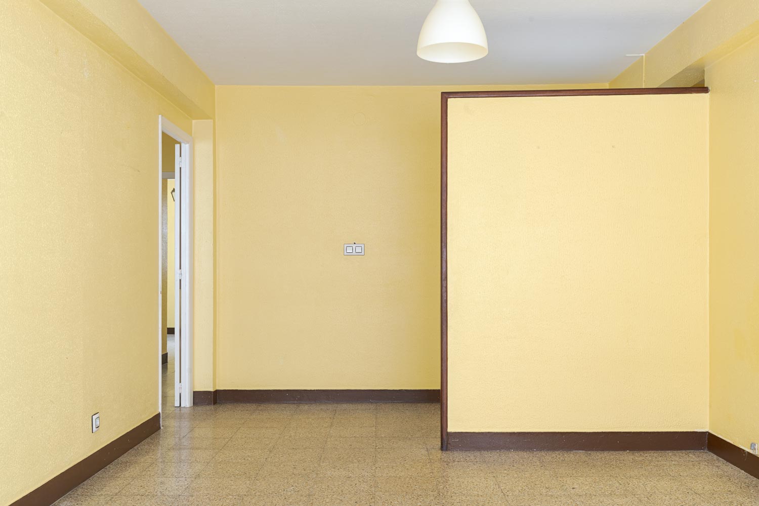 Sala de estar vacía en piso en venta en Sada, con paredes en tono amarillo suave y una disposición amplia, ideal para personalizar. Gestionado por Morando Inmobiliaria.