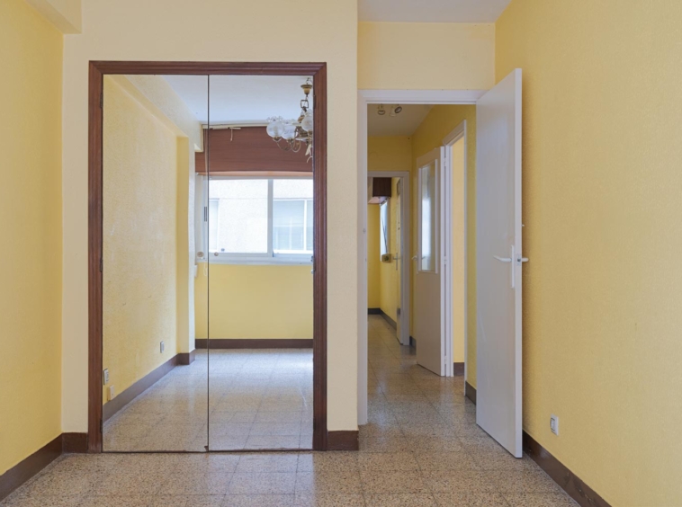 Pasillo con espejo y paredes en amarillo en piso en venta en Sada, gestionado por Morando Inmobiliaria.