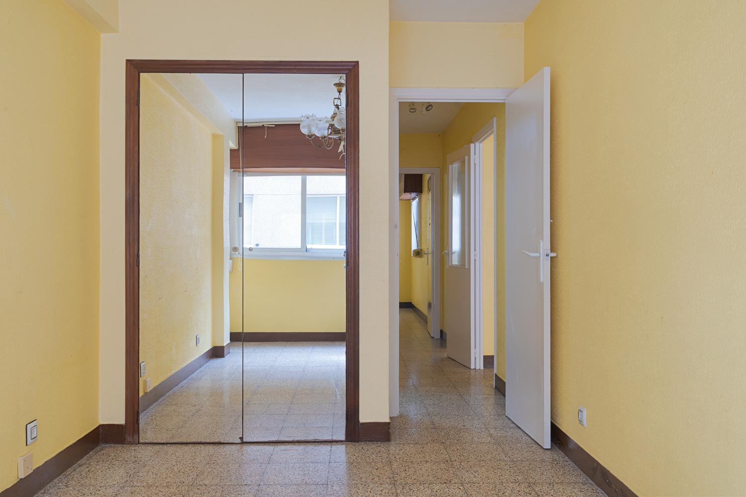 Pasillo con espejo y paredes en amarillo en piso en venta en Sada, gestionado por Morando Inmobiliaria.