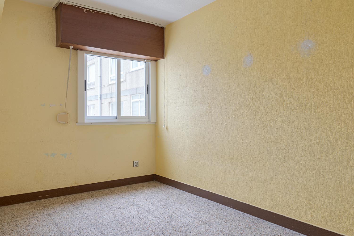 Dormitorio vacío con paredes amarillas y ventana en piso en venta en Sada.